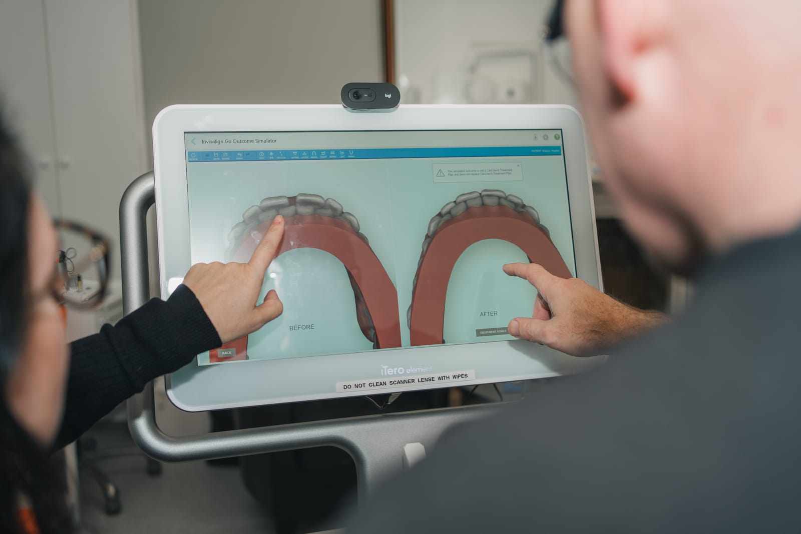 Dentist showing a patient their Invisalign outcome simulation on screen